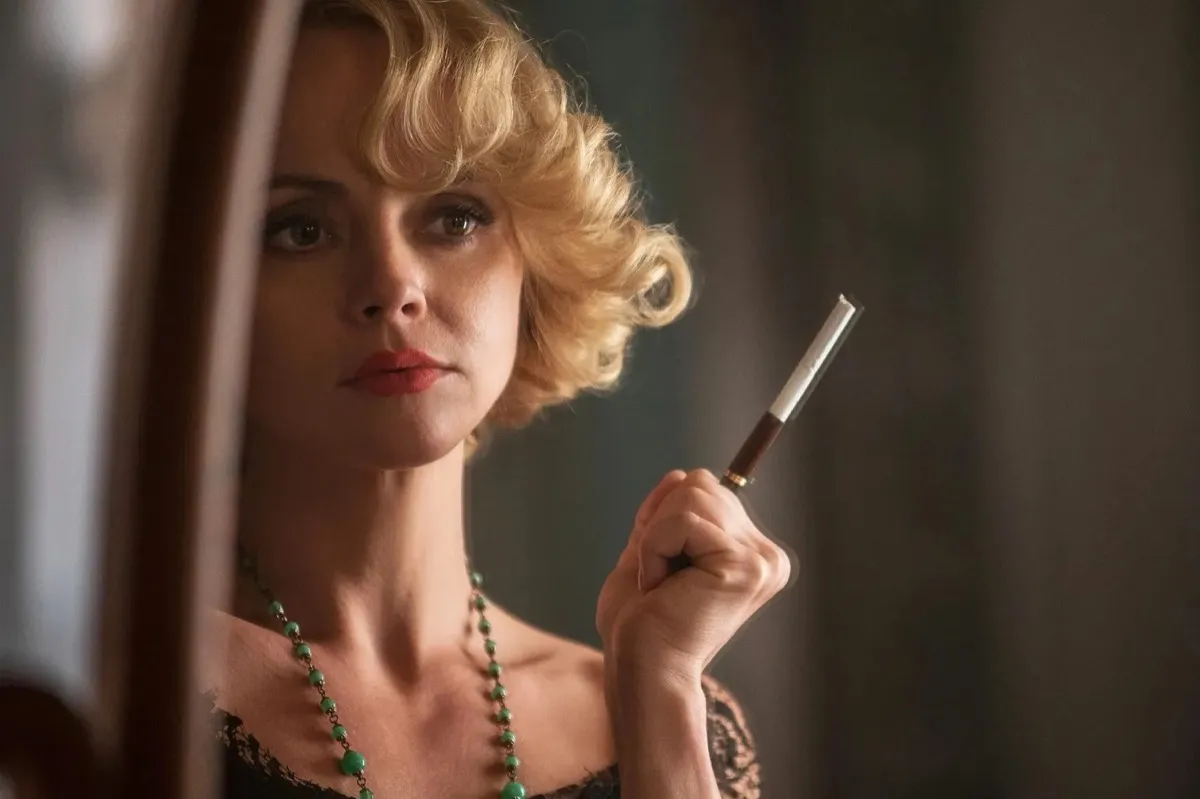Zelda Fitzgerald (Christina Ricci) gazes into a mirror. She has a cigarette holder in her hand. 