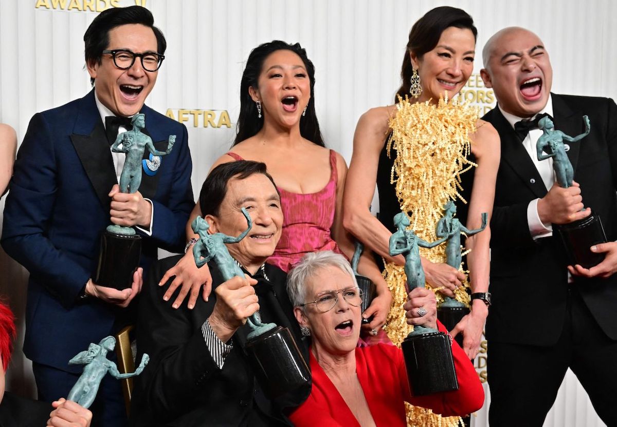 Ke Huy Quan, James Hong, Stephanie Hsu, Jamie Lee Curtis, Michelle Yeoh and Brian Le, smiling while holding their Actor statuettes at the 2023 SAG Awards