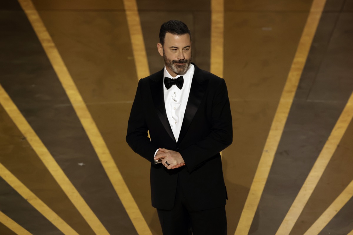 Host Jimmy Kimmel smiles sheepishly onstage at the Oscars