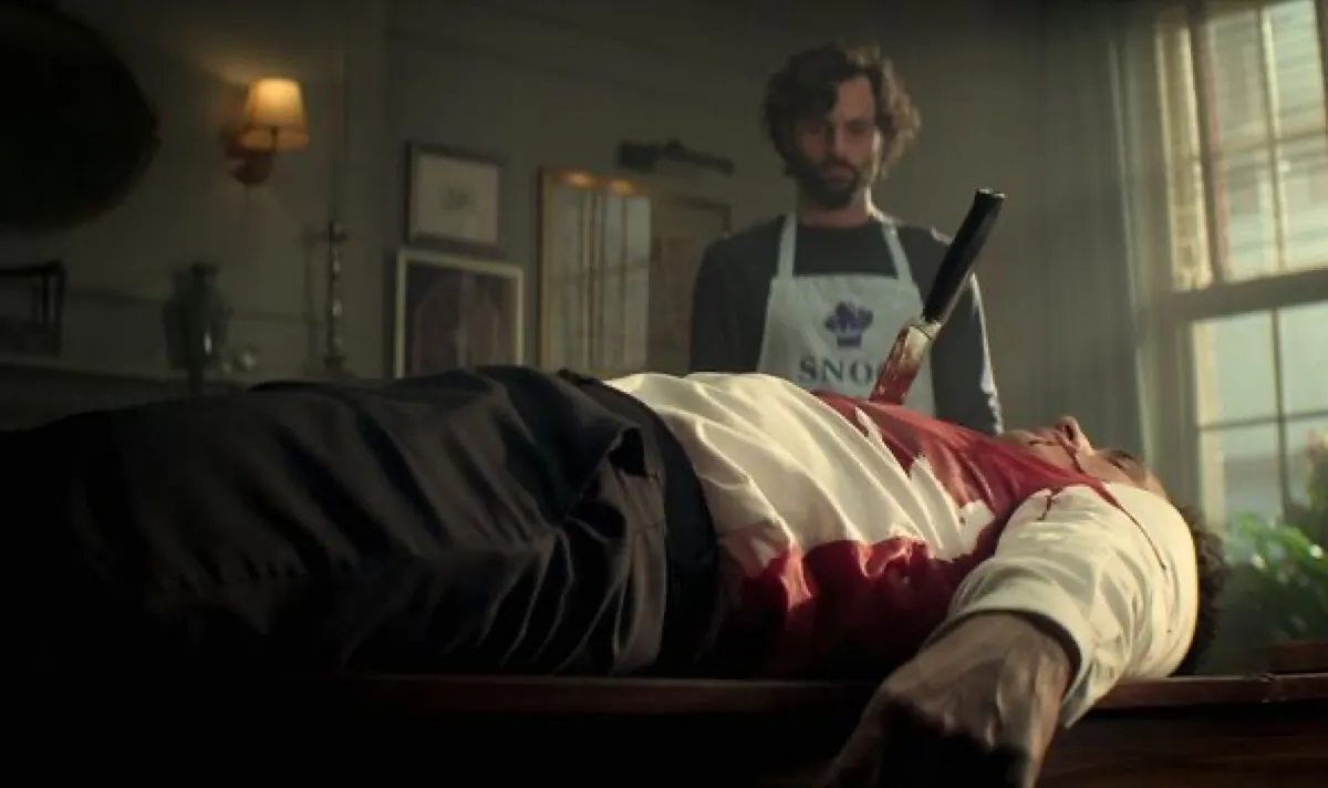 Joe standing over a dead Malcolm, who has a knife in his chest, in 'You' season 4
