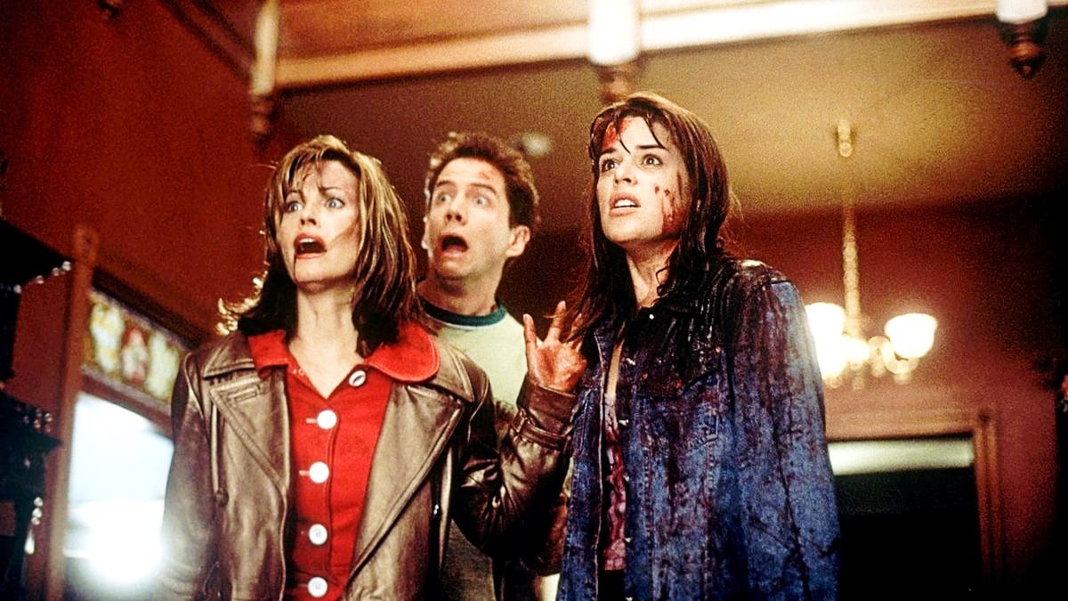 Neve Campbell as Sidney Prescott, Jamie Kennedy as Randy Meeks, and Courteney Cox as Gale Weathers in Scream (1996).