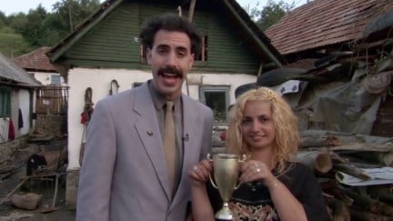 Borat and his wife, who is holding a gold trophy
