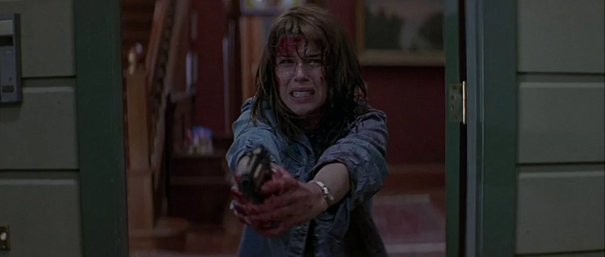A very scared Sidney Prescott holding a gun in Scream