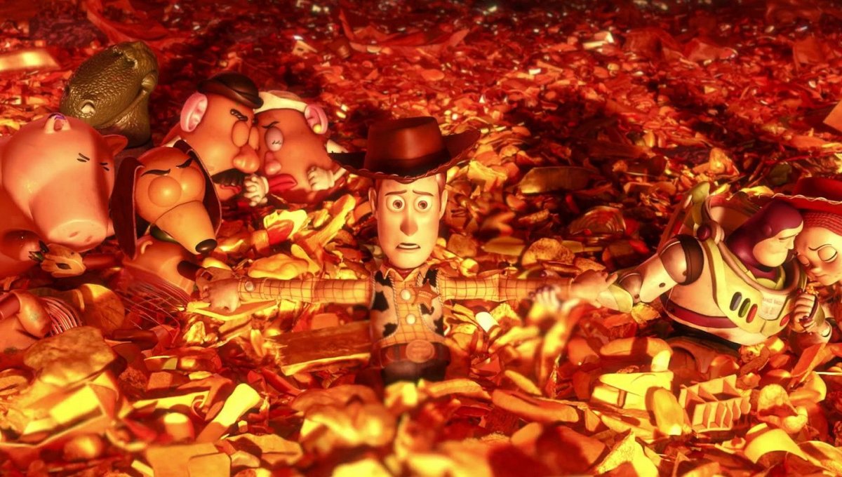 Woody, Buzz and the other toys hold each other as they slide down the trash pile to the incinerator (Disney)
