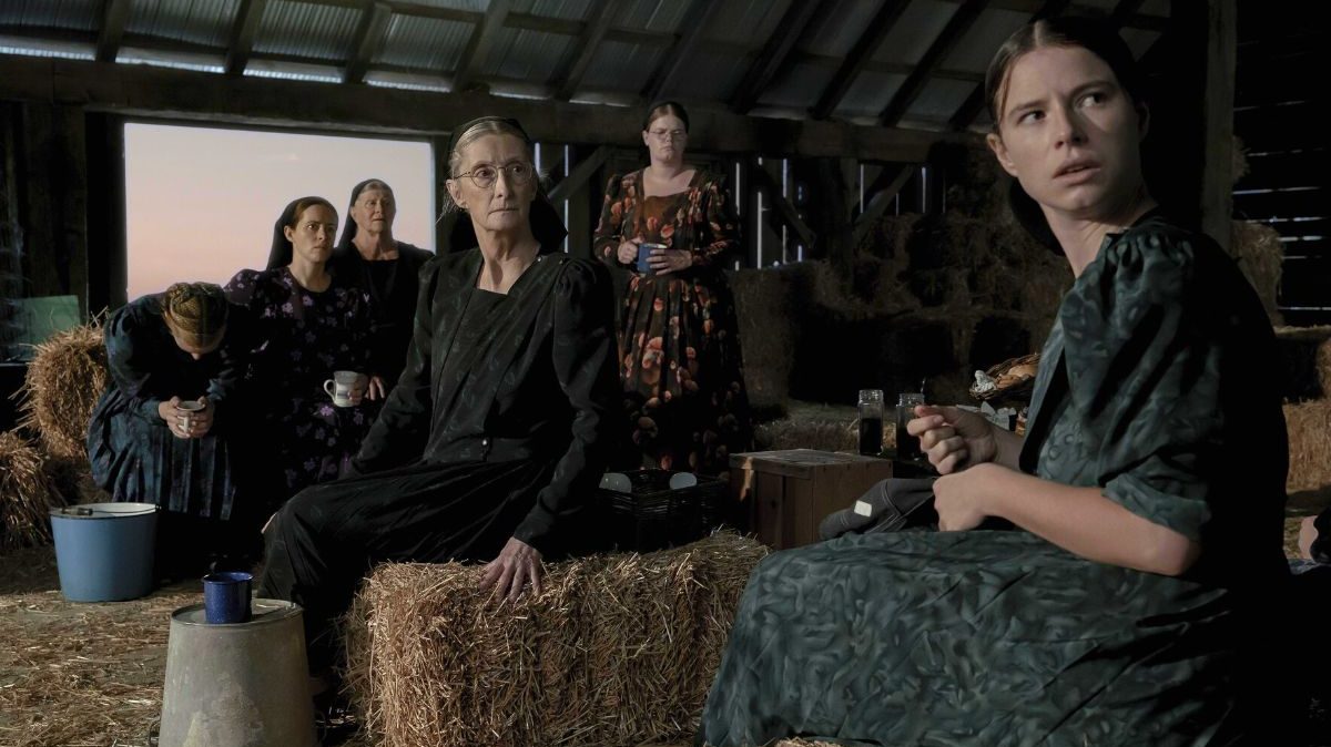 "Women Talking" frame with many of the women in the barn looking horrified.