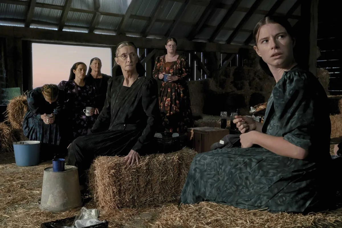 "Women Talking" frame with many of the women in the barn looking horrified.
