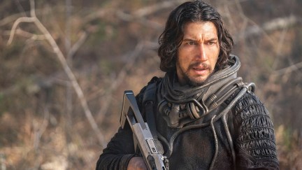 Adam Driver with a gun ready to shoot some dinos in 65