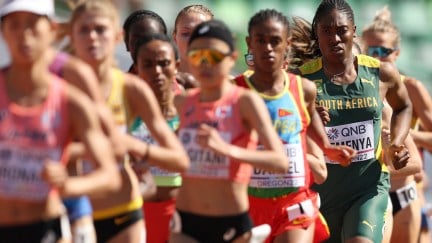 A group of female track athletes running, with Caster Semenya, a tall Black runner, in focus