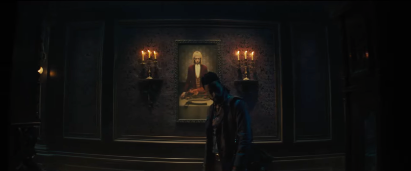 A portrait of the ghost host in the endless hallway scene from the haunted mansion trailer