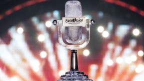 The Eurovision trophy, shaped like a microphone, with a fireworks background.