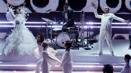 Stephanie Hsu and David Byrne onstage at the Oscars, wearing white.