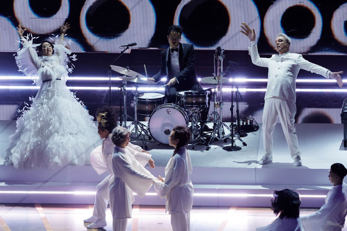 Stephanie Hsu and David Byrne onstage at the Oscars, wearing white.