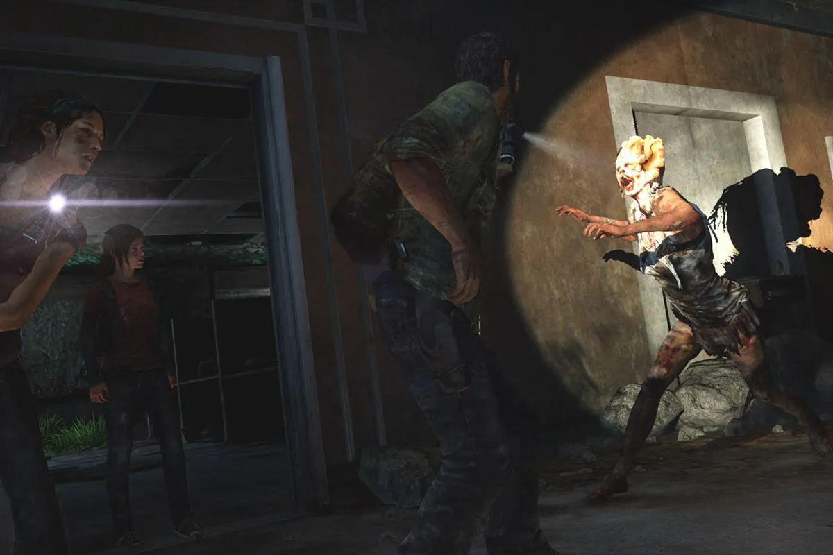 Image from the first "The Last of Us" video game. Tess and Ellie stand in a doorway as a clicker charges at Joel in a dark hotel hallway.