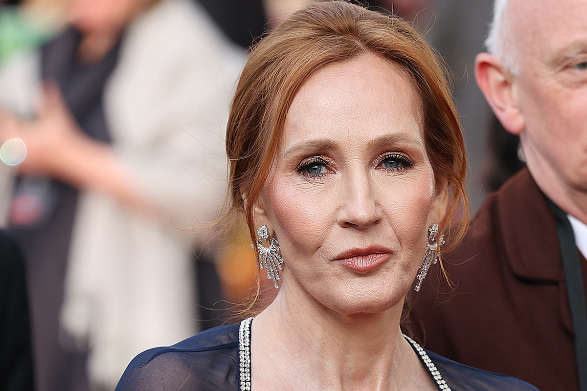 JK Rowling purses her lips and looks stern on a red carpet.