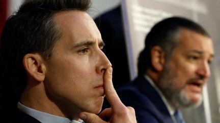 Josh Hawley sits, staring intently, with his index finger pushed up against his nose.