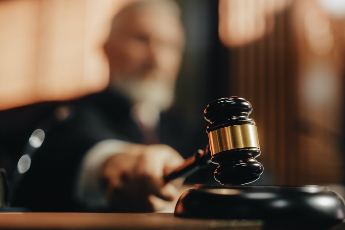 A close-up of a gavel being struck by a judge, blurred in the background.