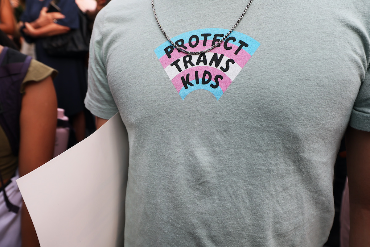 Close-up of a t-shirt reading "protect trans kids"