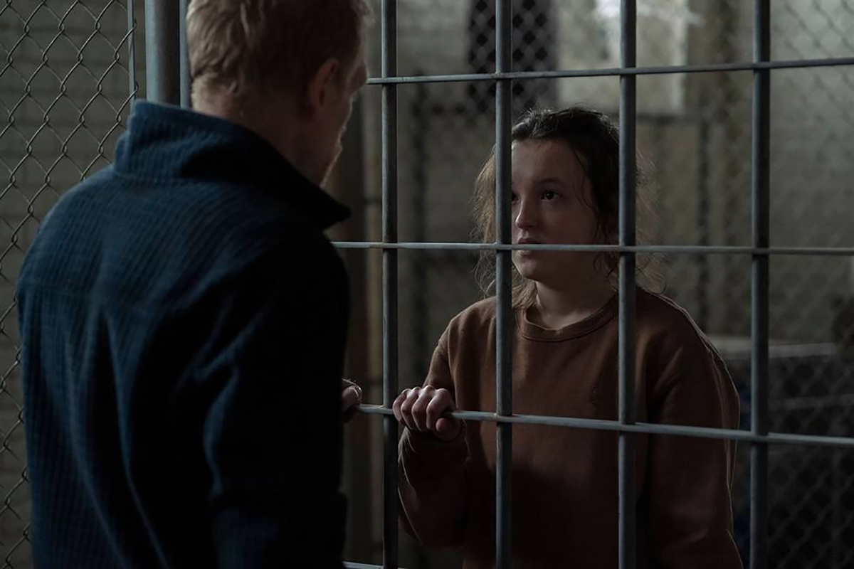 Bella Ramsey as Ellie behind bars in 'The Last of Us' talking to David