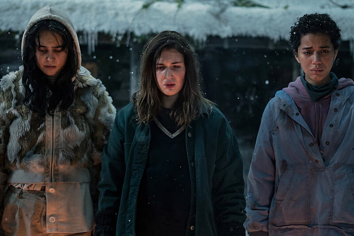 Lottie, Shauna, and Taissa stand in the snow, looking troubled, in Yellowjackets.