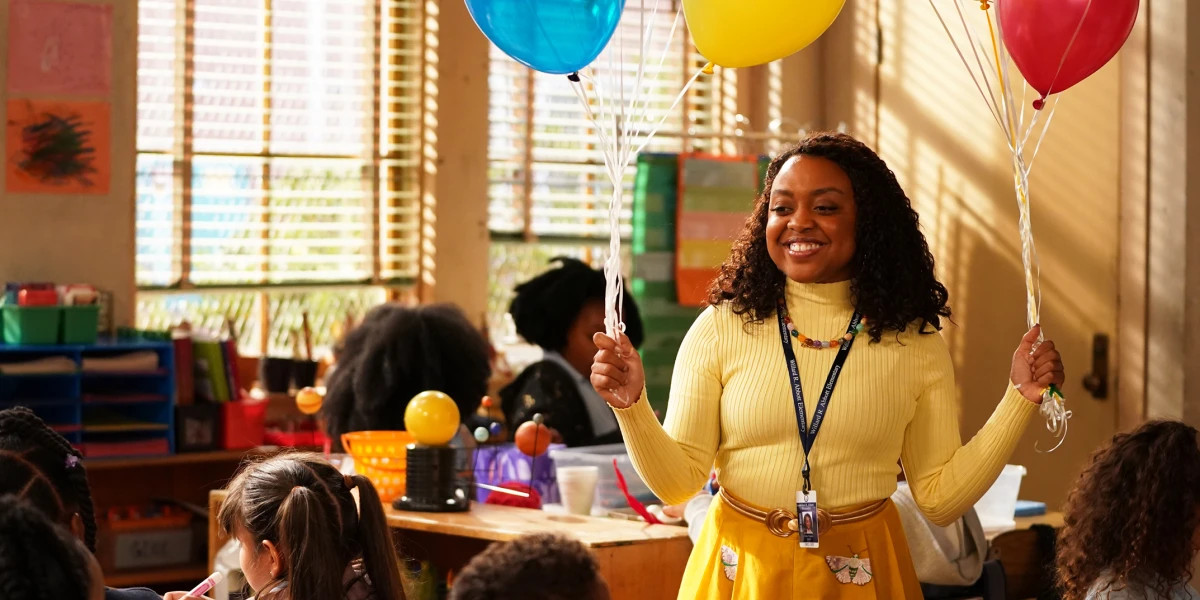 Quinta Brunson as Janine Teagues in Abbott Elementary holding balloons in the classroom