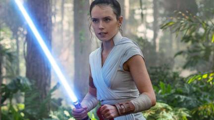 Daisy Ridley as Rey, wielding a lightsaber in a forest in 'Star Wars'