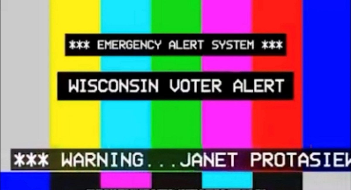 A screengrab from the political ad for Dan Kelly showing a background of brightly colored vertical stripes and the words "Emergency Alert System. Wisconsin Voter Alert."