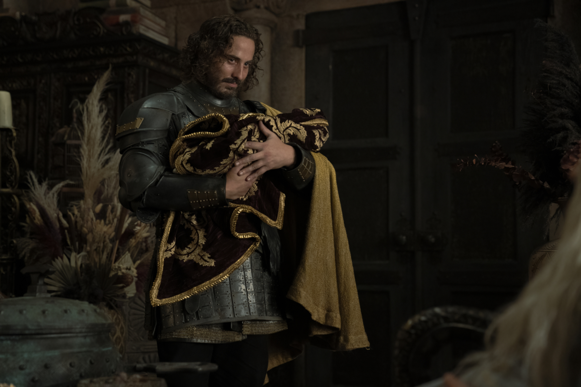 Sir Harwin Strong, played by Ryan Corr, holds the youngest of his sons with Princess Rhaenyra Targaryen in House of the Dragon