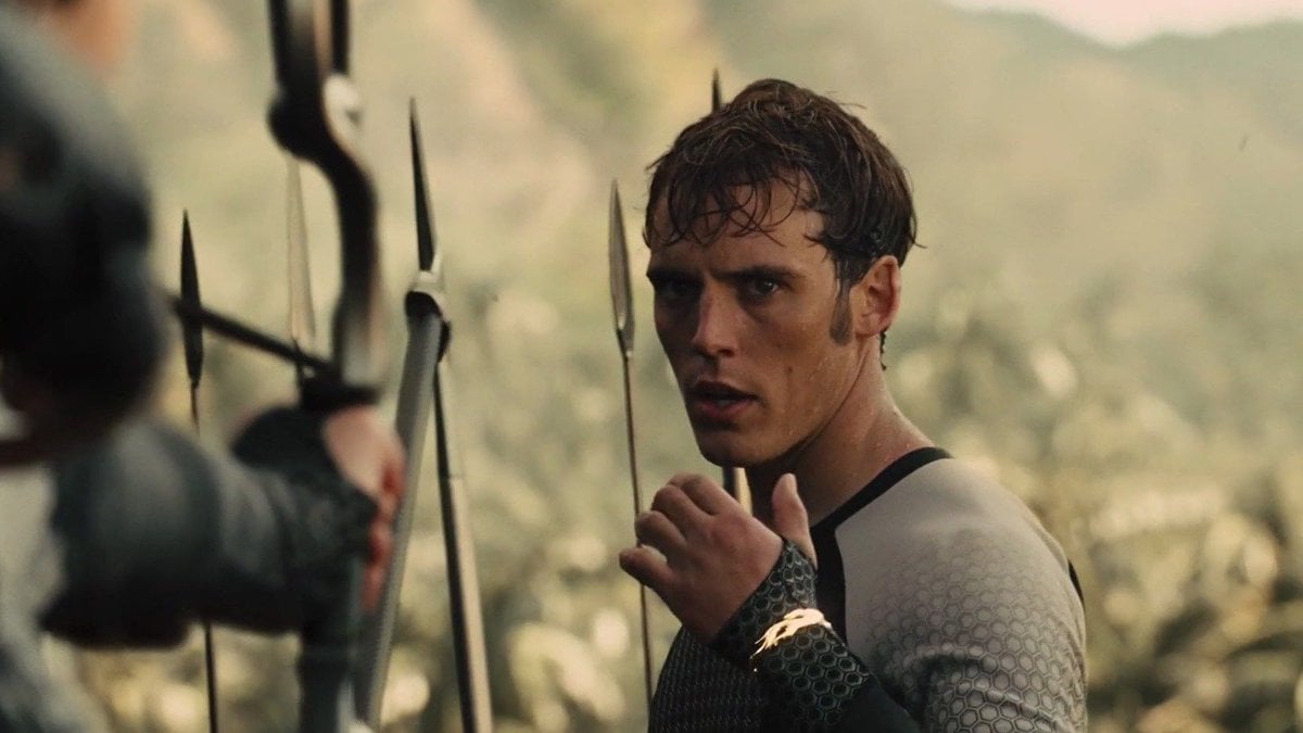 Finnick Odair holds up his wrist with a bracelet on it