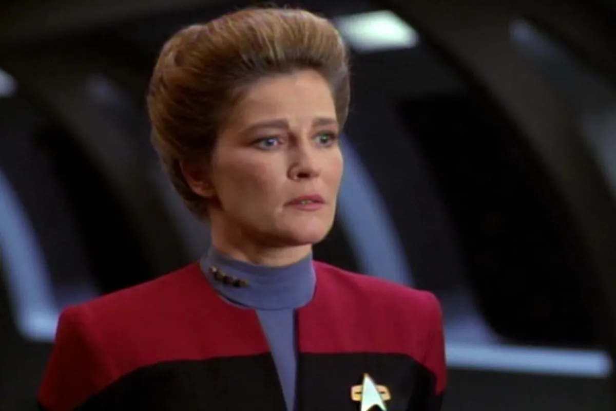 Captain Janeway in 'Star Trek: Voyager': A white woman with a brown updo in a red Star Trek uniform looks perturbed