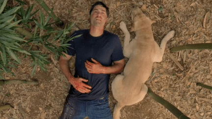 Jack Shephard lays on the ground with his dog