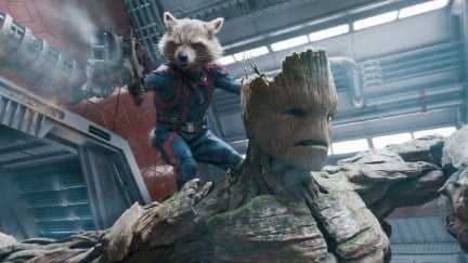 Rocket standing on Groot's shoulder while firing a gun in Guardians of the Galaxy Vol. 3