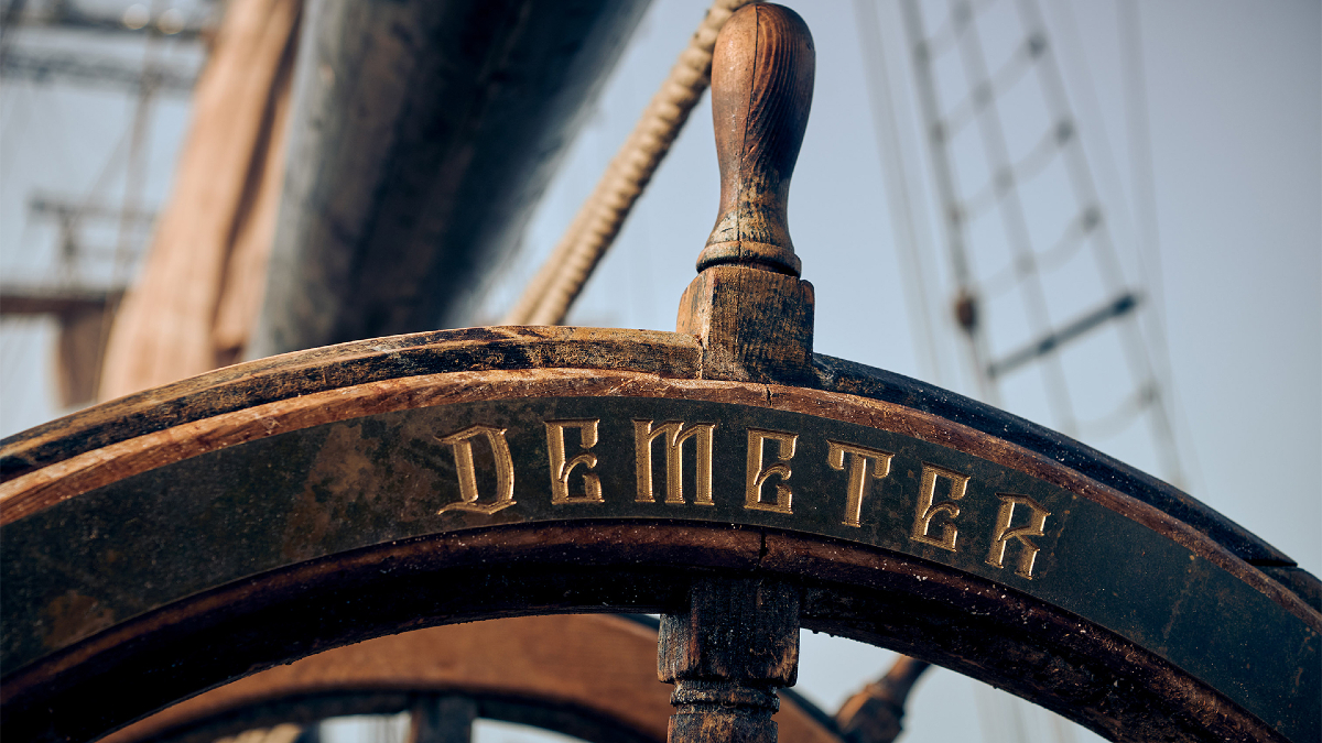 The wheel of an old ship with the name "Demeter" carved into the wood, from 'The Last Voyage of the Demeter'