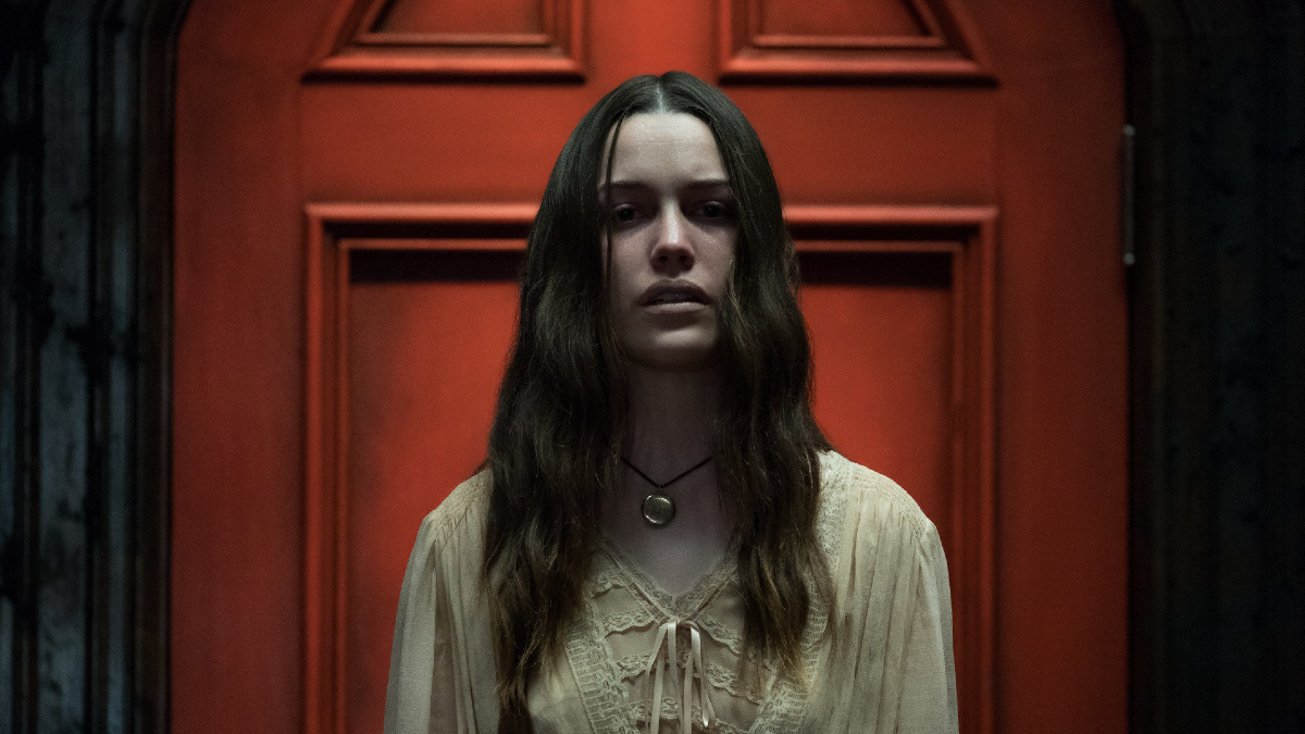 Nell (Victoria Pedretti) stands in front of an eerie red door in 'The Haunting of Hill House'
