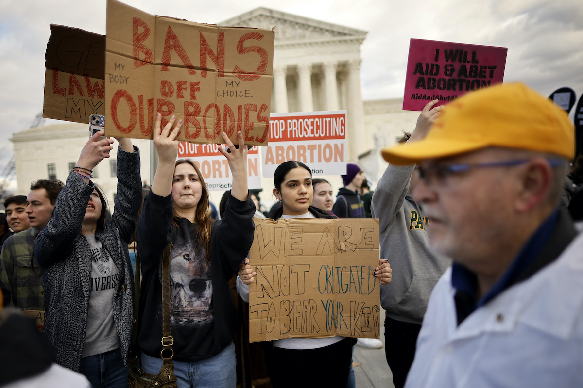 Abortion rights protesters hold signs during a demonstration.