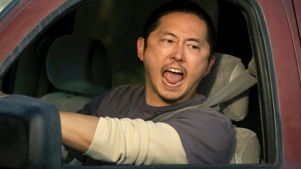 An Asian man (Steven Yeun) yells out the driver's side window of a truck.
