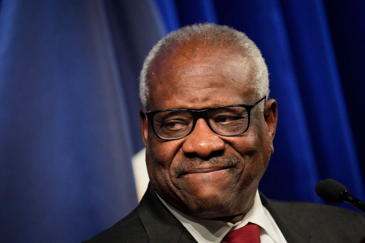 Clarence Thomas gives a tight-lipped smile.
