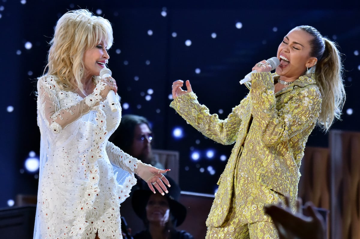 Dolly parton and Miley Cyrus perform on stage.