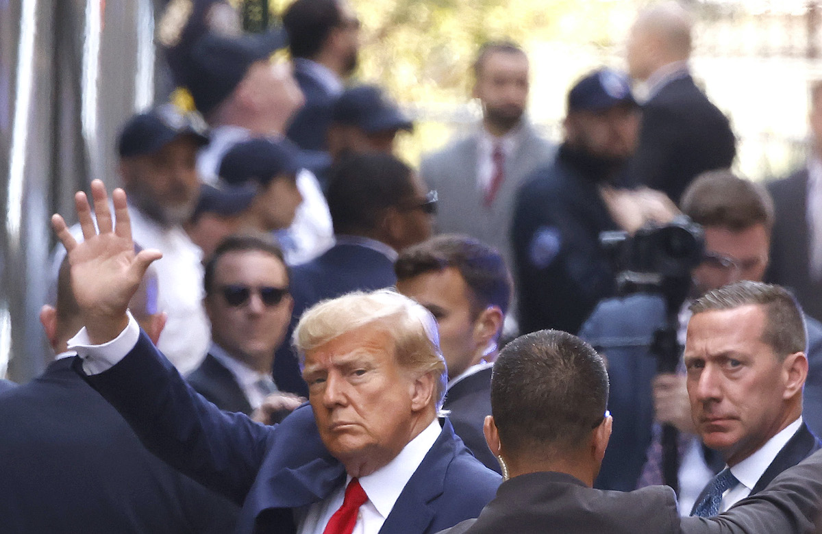 Donald Trump waves at the camera from a New York City street.