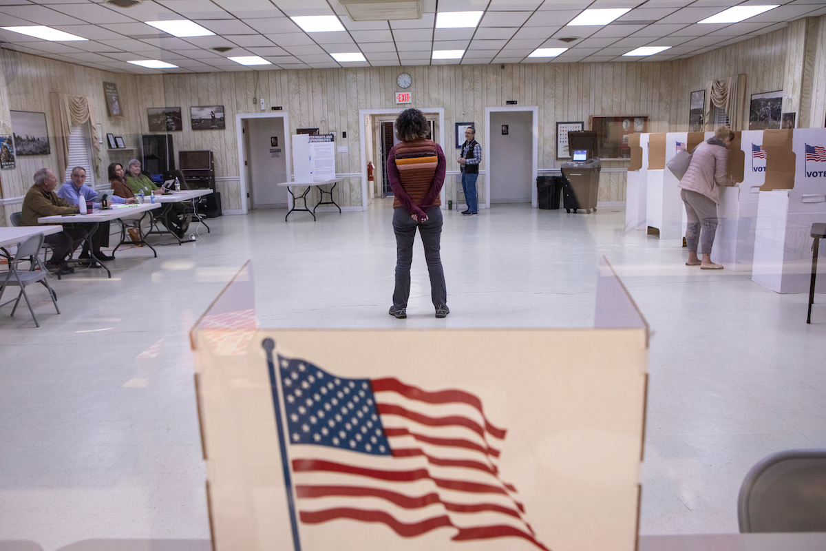 A polling place set up inside a small bare room.
