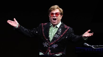 Sir Elton John Performs live on stage in a sparkly tuxedo.