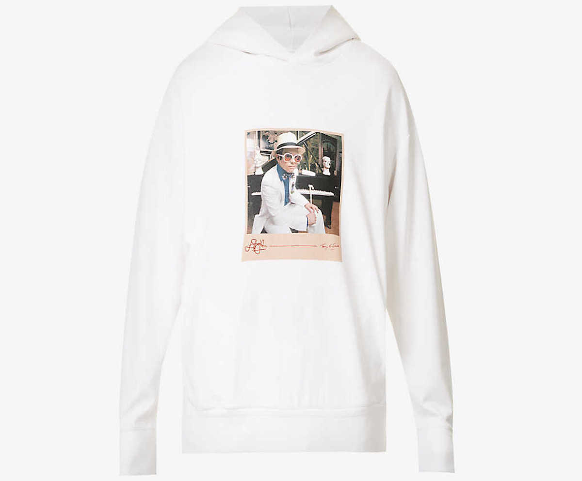 A white hoodie with a disproportionately small photograph of Elton John in the middle of the chest.