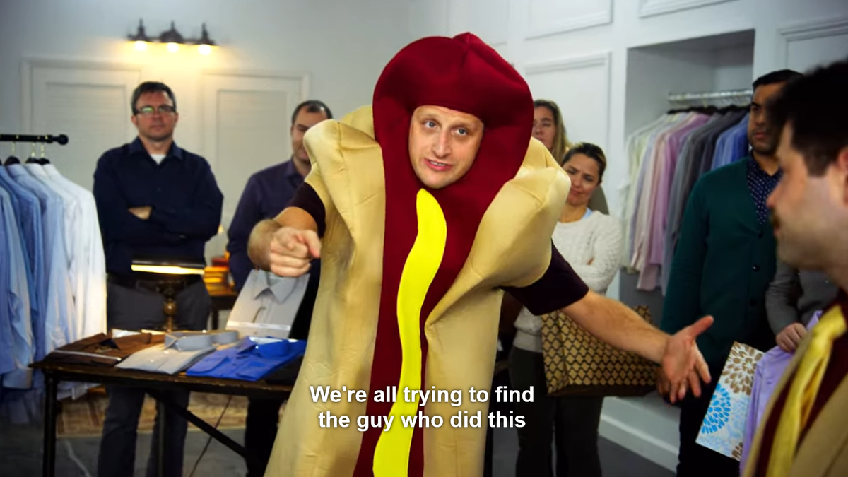 Tim Robinson wears a hot dog costume in a clothing store. Subtitles read, "We're all just trying to find the guy who did this."