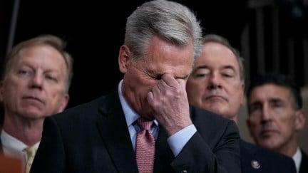 An old white man (Kevin McCarthy, buries his face in his hand as he pinches his nose.
