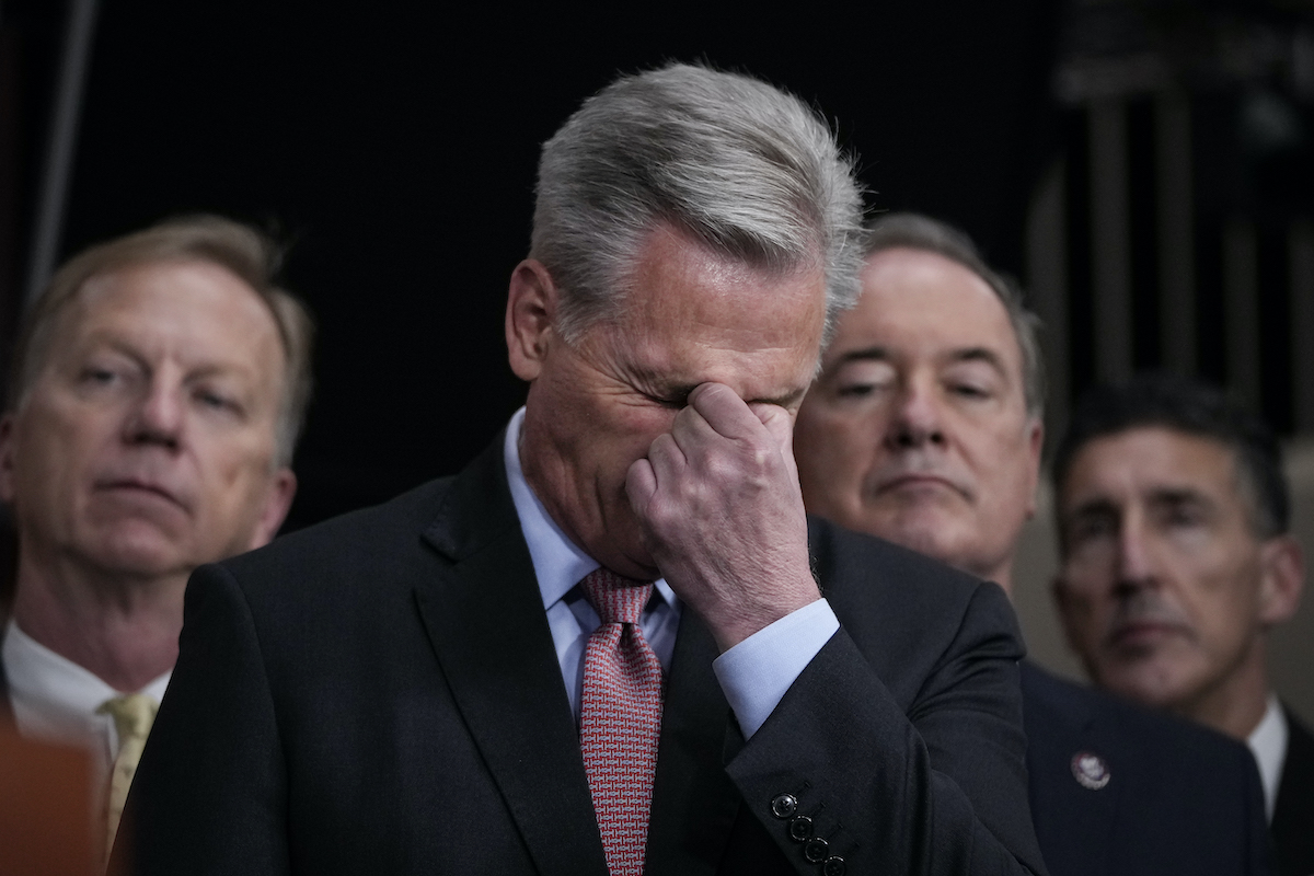 An old white man (Kevin McCarthy, buries his face in his hand as he pinches his nose.