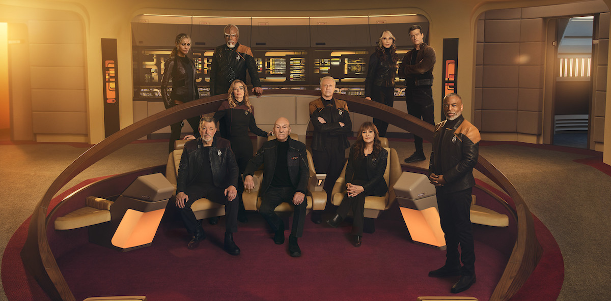 The original cast of Star Trek: The Next Generation, along with Raffaella, Seven, and Jack, pose on the bridge of the Enterprise.