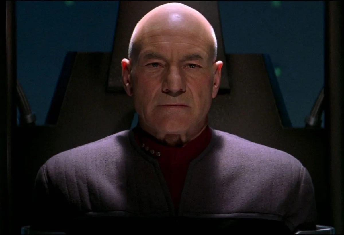 Captain Picard in Star Trek Nemesis: An older bald, white man looks grimly at the camera.
