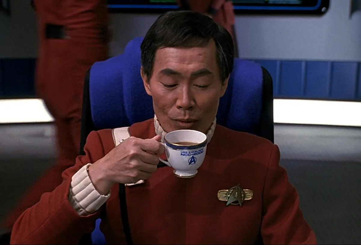 George Takei as Captain Sulu in 'Star Trek': An older Japanese man in a red and white Starfleet uniform drinks tea from a white tea cup.