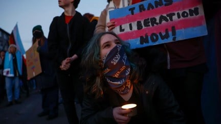 Protesters at a demonstration, holding a sign reading 