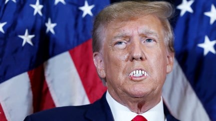 A photo of Donald Trump with vampire teeth superimposed.