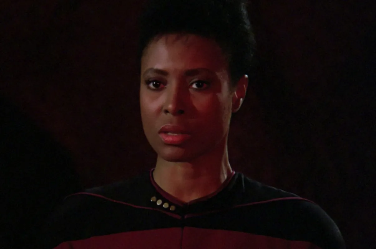 Ursaline Bryant as Tryla Scott in 'Star Trek: The Next Generation': A Black woman in a red and black Starfleet uniform looks at the camera with a disturbed expression